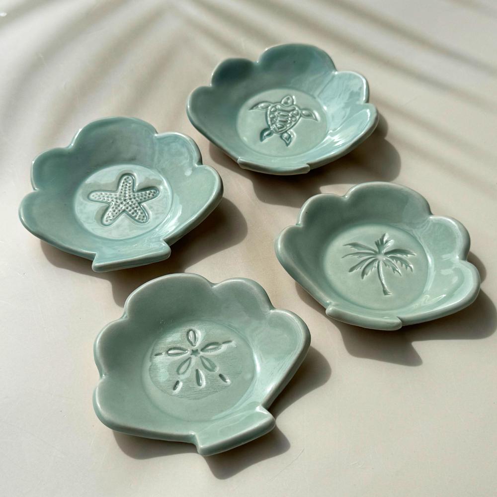 ceramic dishes in the shape of a shell with tropical imprints